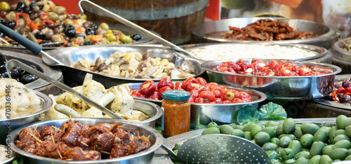 Food stall at a market in Catania, Sicily. Tomatoes, olives, spring onions and other delicacies