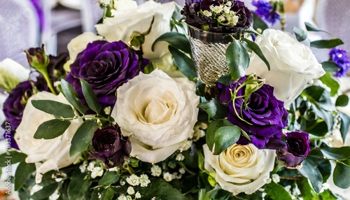 white roses and dark purple accents in floral centerpiece