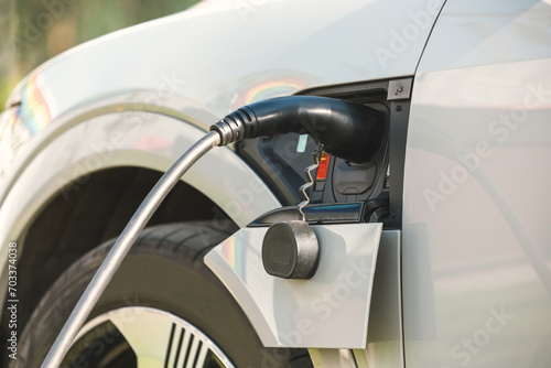 Charging an electric car with a connected power cable close-up. The concept of ecological transport.