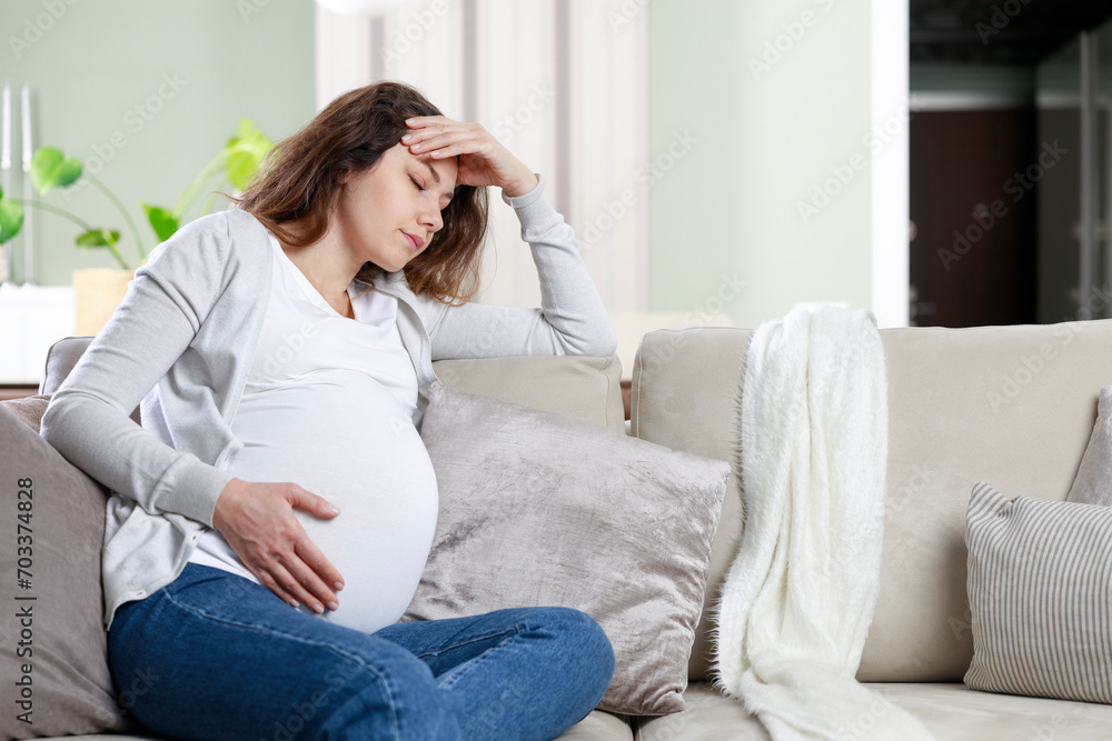 Young woman suffering from nausea and headache during pregnancy Young woman suffering from nausea and headache during pregnancy