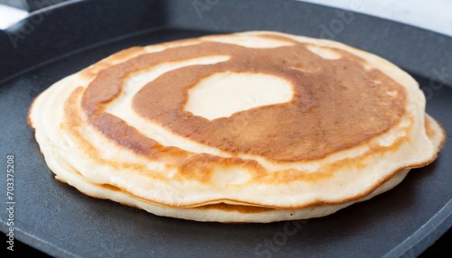 cooking wheat pancakes for american breakfast on black griddle