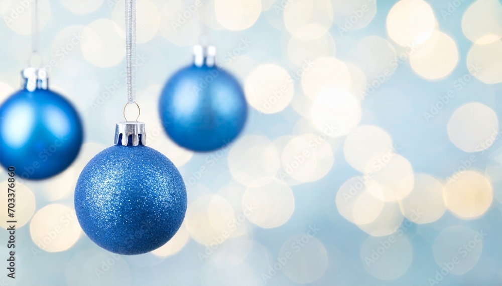 three blue christmas bauble balls hanging in front of bokeh background with copy space christmas or new year template three blue christmas bauble balls hanging in front of bokeh background with copy space christmas or new year template