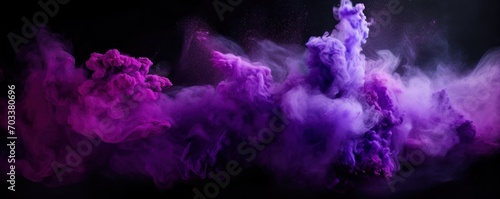 Explosion of violet colored powder on black background photo