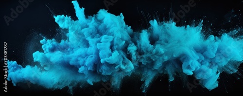 Explosion of turquoise blue colored powder on black background photo