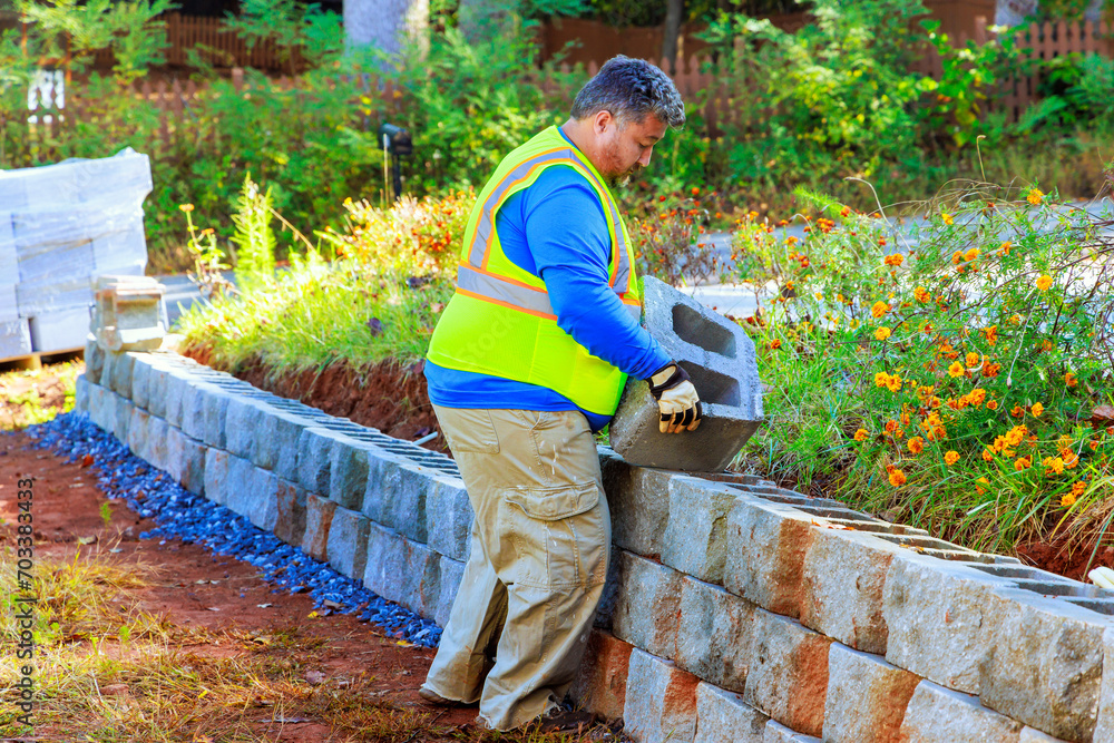 Contractor is installing concrete block walls as part construction of