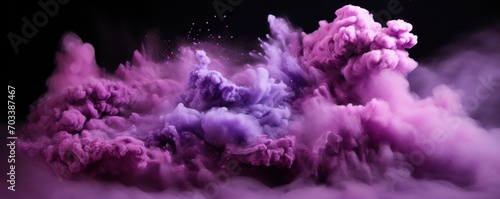 Explosion of lilac colored powder on black background photo