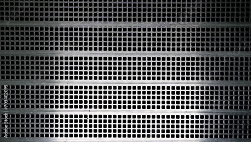 Metallic gray mesh on a gray background. Abstract metal grid. Abstract gray background with metallic square grid and changing lighting angle photo