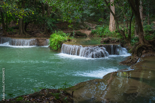 Tropical landscape with waterfall in evening. Muak Lek River and banyan trees with bizarre roots in Chet Sao Noi National Park  Thailand