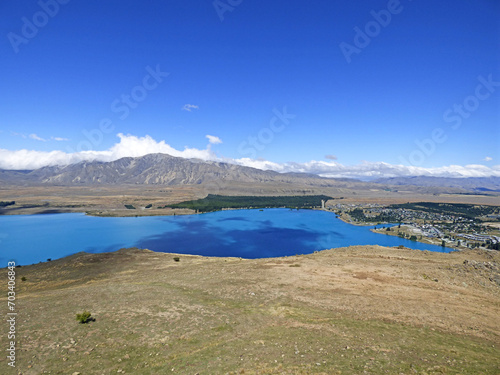 Lake Tekapo viewed from Mt. John Observatory. Clear blue waters in the summer. New Zealand South Island, Aoraki National park. Mountains in the background.