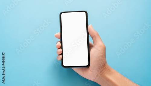 Hand using smartphone with blank screen, isolated on blue background photo
