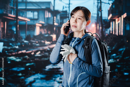 災害が発生し電話が繋がらずに困る女性 photo