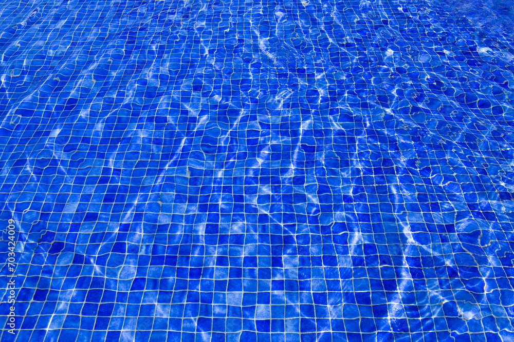 Blue tiles pool with ripple water reflection .
