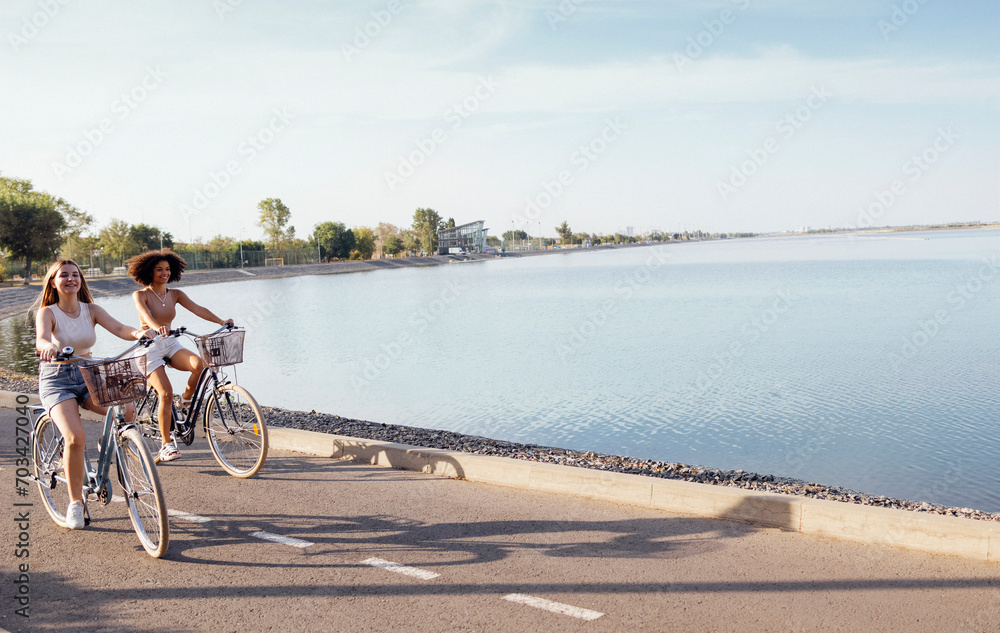 Fototapeta premium Teenagers of different nationalities and appearance on bicycles ride along a city street