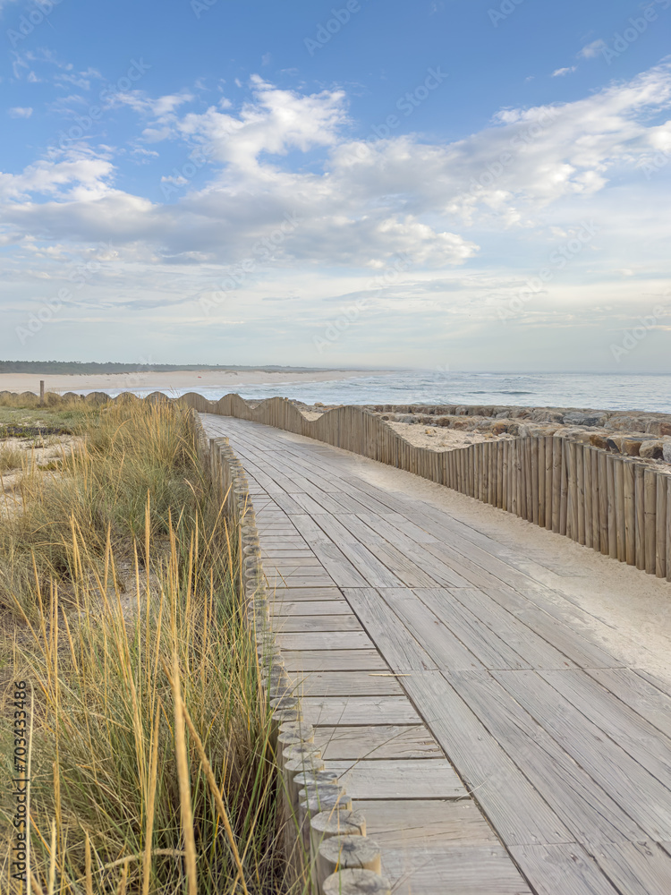 A wood pedestrian walkways, build over a sand dune that is used to give beach access in Furadouro beach, glows at sunset. Ovar, Aveiro, Portugal, Europe A wood pedestrian walkways, build over a sand dune that is used to give beach access in Furadouro beach, glows at sunset. Ovar, Aveiro, Portugal, Europe