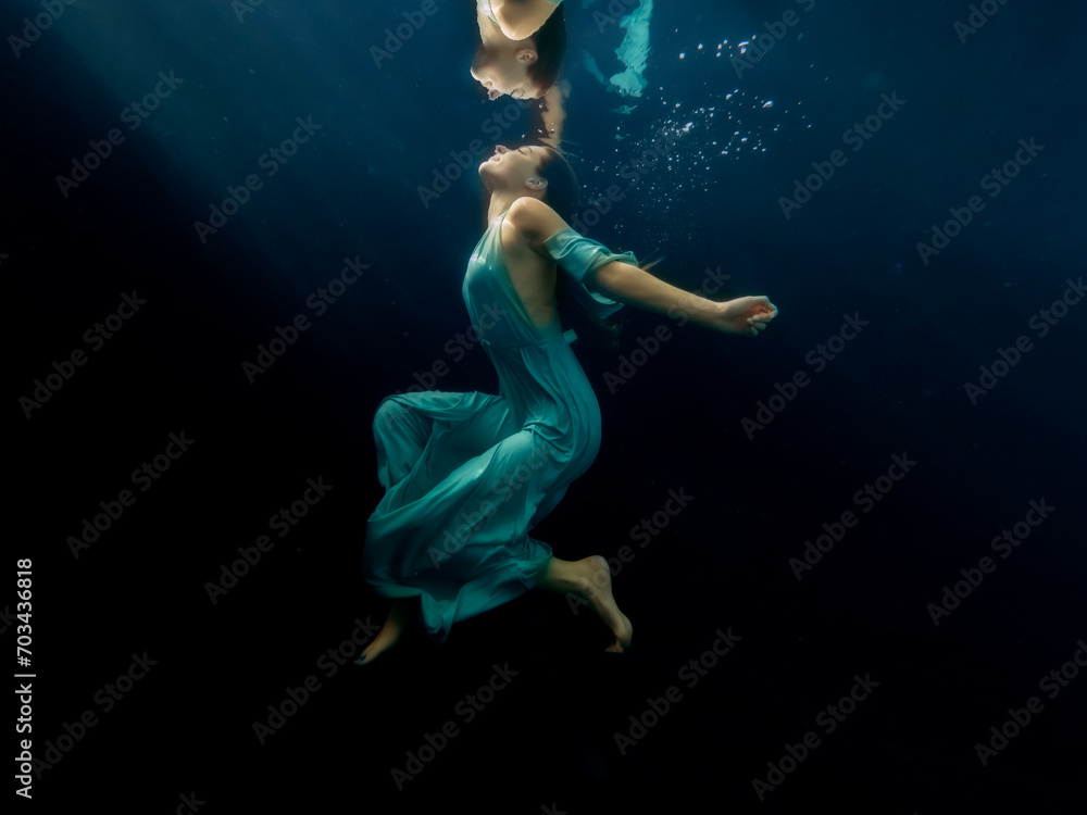 Obraz premium Halee Grindo swimming underwater with long dresss and chiffon