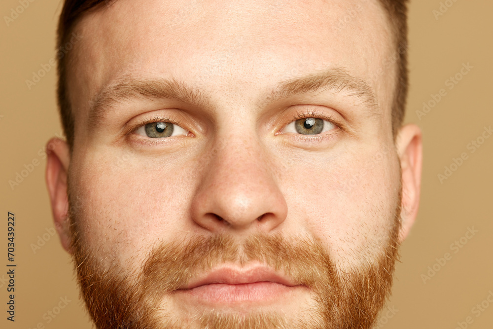 Headshot. Close up portrait of attractive young man with bear, well kept, smooth skin against beige studio background. Concept of beauty treatment, selfcare and hygiene, cosmetic, spa. Ad Headshot. Close up portrait of attractive young man with bear, well kept, smooth skin against beige studio background. Concept of beauty treatment, selfcare and hygiene, cosmetic, spa. Ad