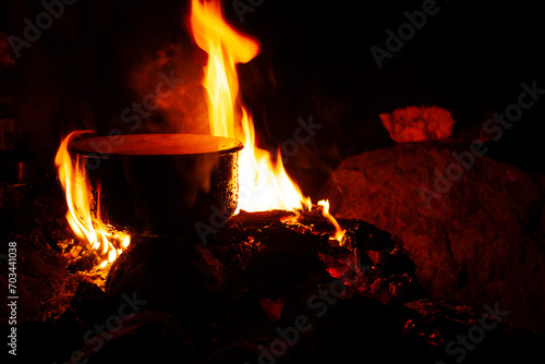 dark scene of camp fire with pot  lifestyle people concept