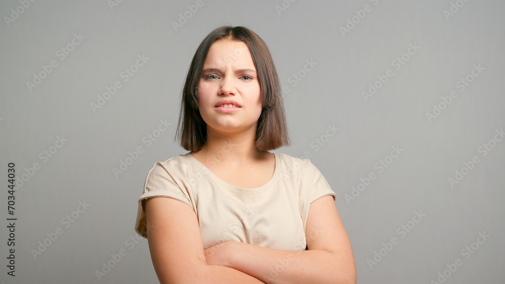 Picture of angry young latin woman standing isolated over gray background. Looking at camera Picture of angry young latin woman standing isolated over gray background. Looking at camera