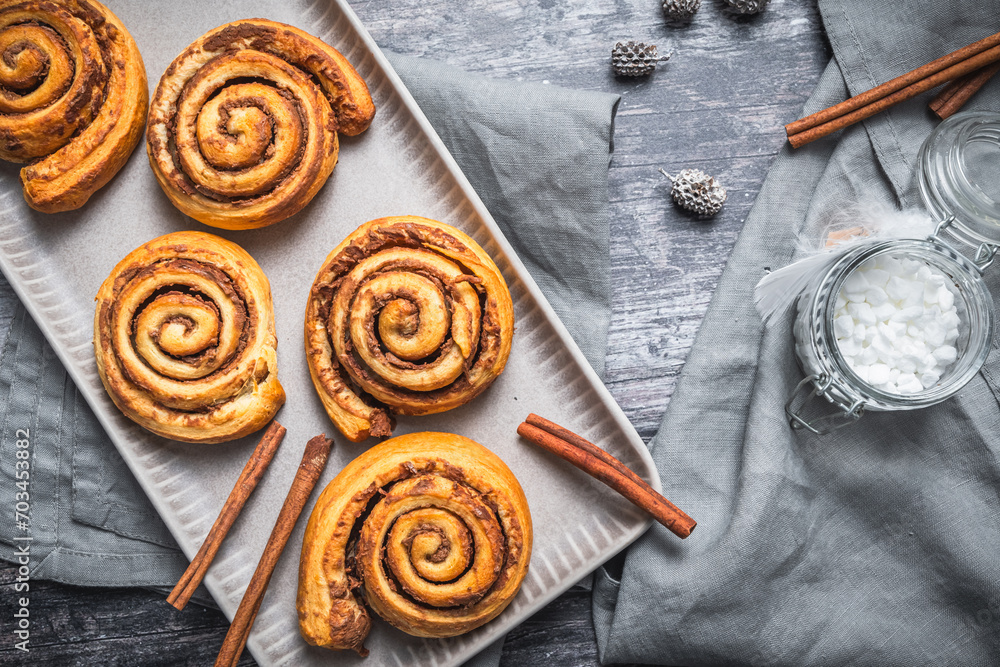 Homemade cinnamon rolls on a gray earthenware tray on gray background Homemade cinnamon rolls on a gray earthenware tray on gray background