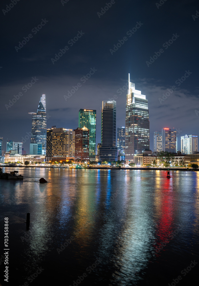 Ho Chi Minh City skyline and the Saigon River. Amazing colorful night view of skyscraper and other modern buildings at downtown. Travel concept Ho Chi Minh City skyline and the Saigon River. Amazing colorful night view of skyscraper and other modern buildings at downtown. Travel concept