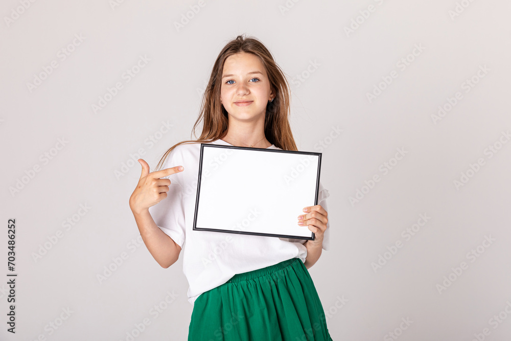 White banner .Teenager girl hold white blank paper. Young smiling woman show blank board. Close up female model portrait on white background.