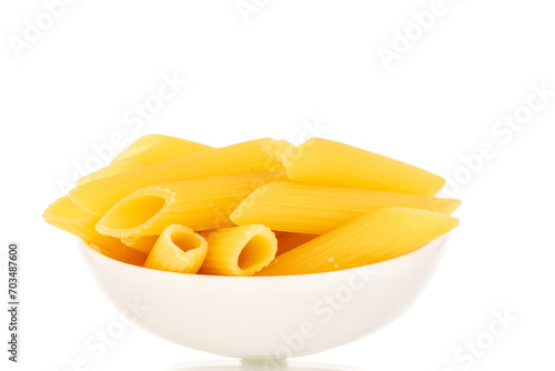 Uncooked pasta, penne, in a white ceramic plate, macro, isolated on white background.