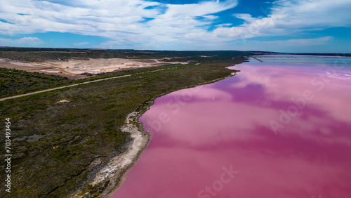 Aerial view of the banks of Hutt Lagoon Pink Lake and the ocean drive way during a blue sky day - Western Australia