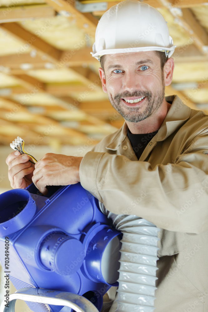 friendly smiling male worker holding electrical connections for ventilation system friendly smiling male worker holding electrical connections for ventilation system
