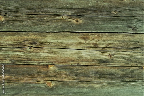 Fragment of an old natural wooden wall. The cracked wooden wall of an old building.