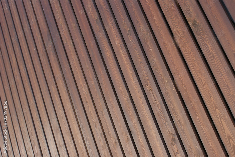 A wall of light brown wooden boards. Background from wooden boards.