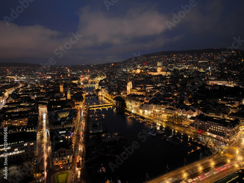 Aerial view of Swiss City of Zürich with cityscape, skyline, city lights, Limmat River and Lake Zürich on a dark winter night. Photo taken January 5th, 2024, Zurich, Switzerland.