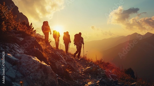 Four youthful adventurers with knapsacks trek through the mountains during sunset.