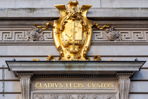 Blason doré sur la façade du Palais de Justice de Paris, France avec le mot 'LEX' (latin pour 'LOI') et une épée, et la devise latine 'Gladius legis custos' (traduction : Le glaive gardien de la loi) photo