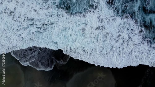 Play of waves on a black sand beach