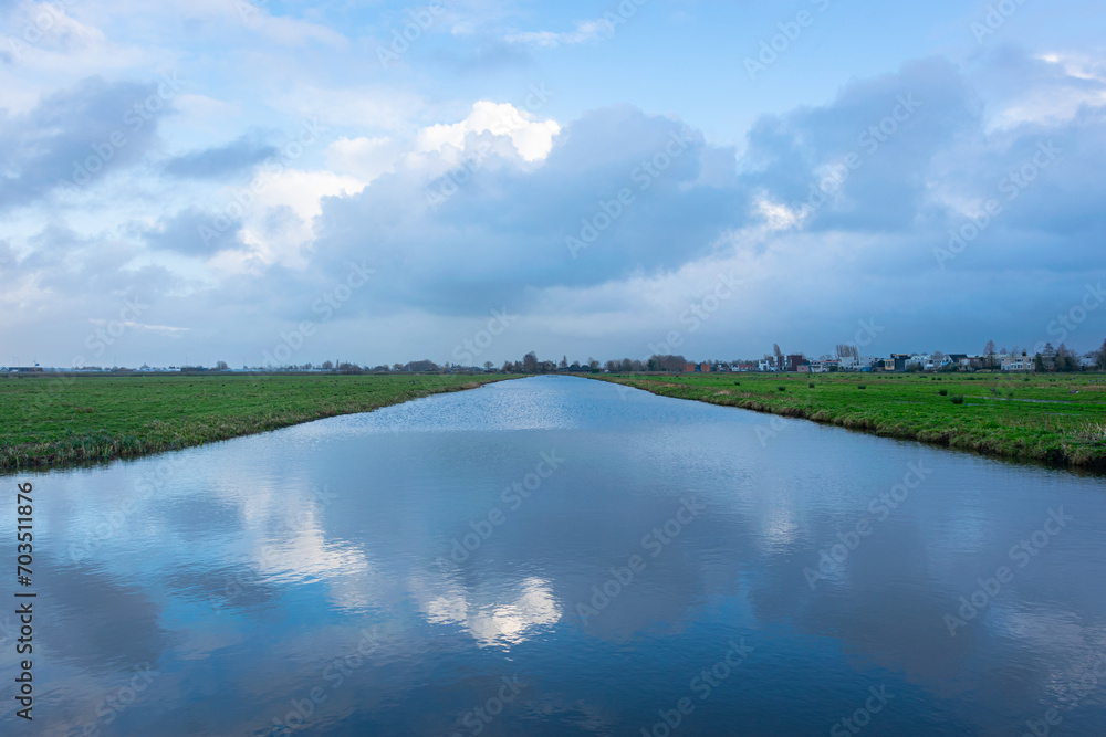 Serene image of clouds over a wide ditch in the Dutch polder landscape