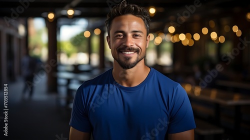 Close up portrait of young smiling handsome guy in blue t-shirt isolated on a background