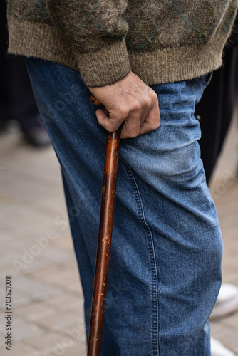 Unrecognizable elderly man walking around town with a cane 