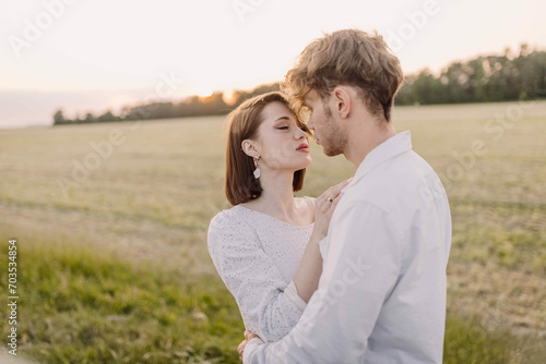 couple in love on a date in nature hugging in a white outfit in the summer. Love, happiness of a young Caucasian couple.