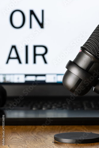 Podcast production studio with professional microphone and lap to with phrase On Air close up. Vertical image.