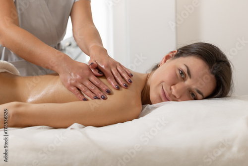 Closeup Shot Of Therapist Lady Massaging Back Of Attractive Mature