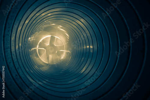 smoke in the ventilation duct of the air system of a shopping center, on a blurred background of the exhaust fan