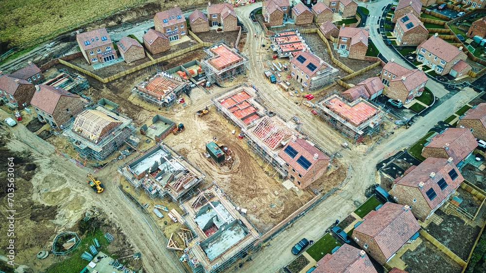 Aerial view of a residential construction site with partially completed houses and infrastructure. Aerial view of a residential construction site with partially completed houses and infrastructure.