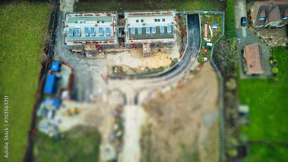 Aerial view of a residential construction site with unfinished houses and excavated land.