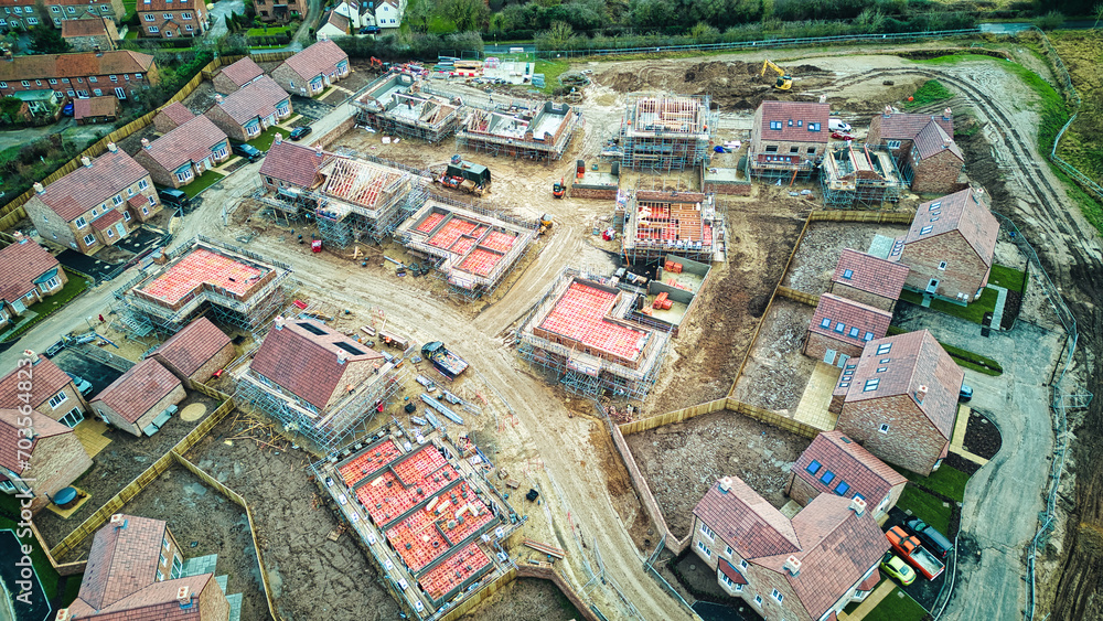 Aerial view of a residential development under construction with partially built houses and infrastructure. Aerial view of a residential development under construction with partially built houses and infrastructure.