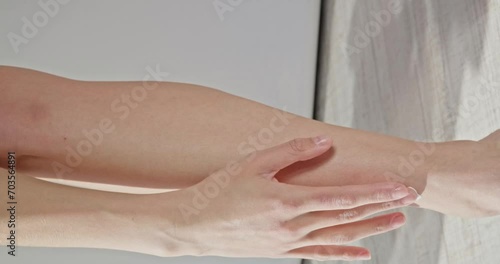 Anonymous woman putting lotion on leg after showering in slow motion. Crop view of young female after shower applying body lotion on smooth leg skin seductively. Concept of skin care, cosmetology.