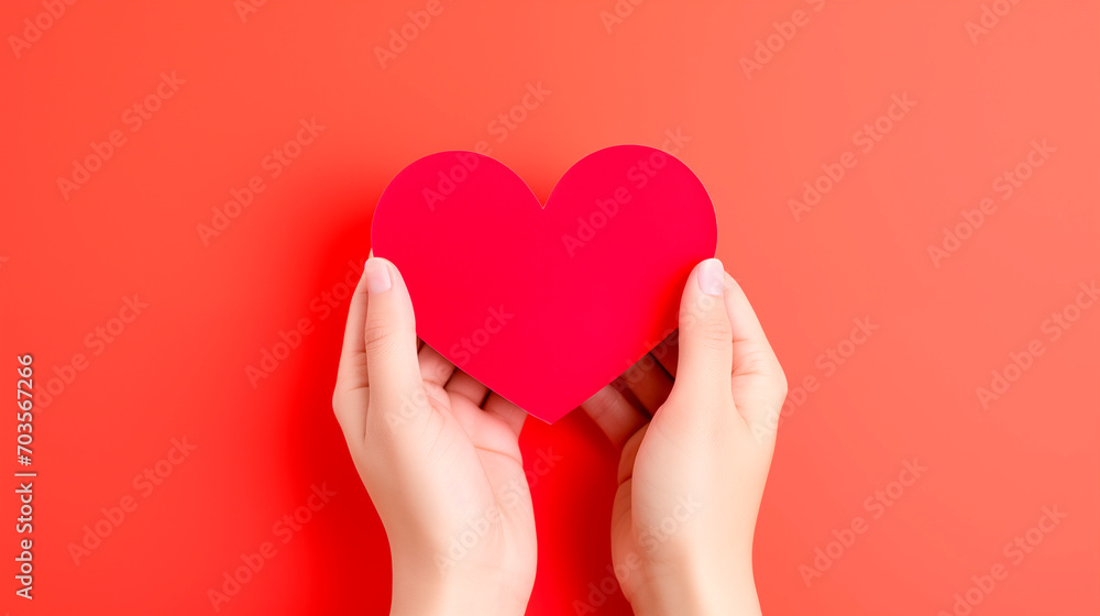 Female hands holding a paper red heart on a red background with copy space. love, health care, world mental health day, organ donation, Female hands holding a paper red heart on a red background with copy space. love, health care, world mental health day, organ donation,
