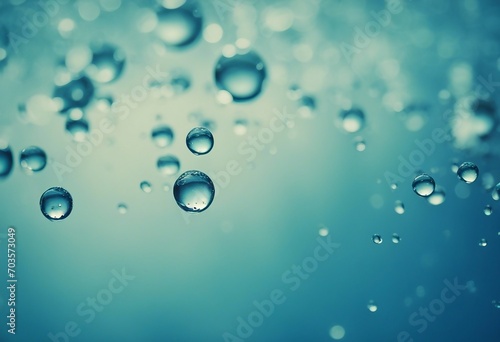 Water drops falling on a light blue wallpaper