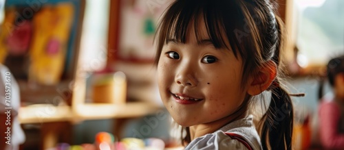 Asian child participating in art workshop at school.