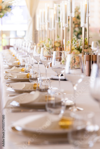 Serving the festive table at a wedding event. Decorating the wedding table with bouquets of flowers. Cutlery at a party 