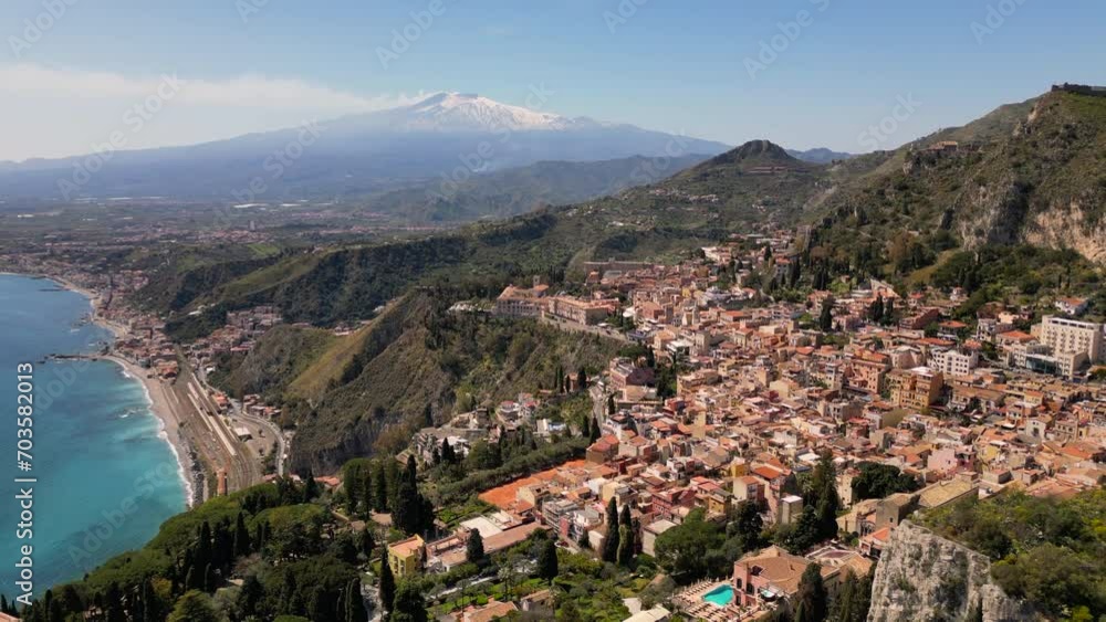 Taormina, Sicily, Italy. Cityscape drone aerial view. Old Greek theatre ruins with active eruption volcano Etna background. Popular travel destination in Europe, UNESCO historical heritage Taormina, Sicily, Italy. Cityscape drone aerial view. Old Greek theatre ruins with active eruption volcano Etna background. Popular travel destination in Europe, UNESCO historical heritage